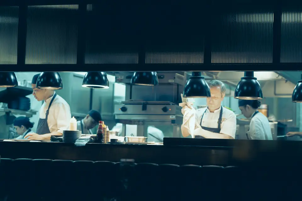 Une brigade de cuisine au travail derrière le passe