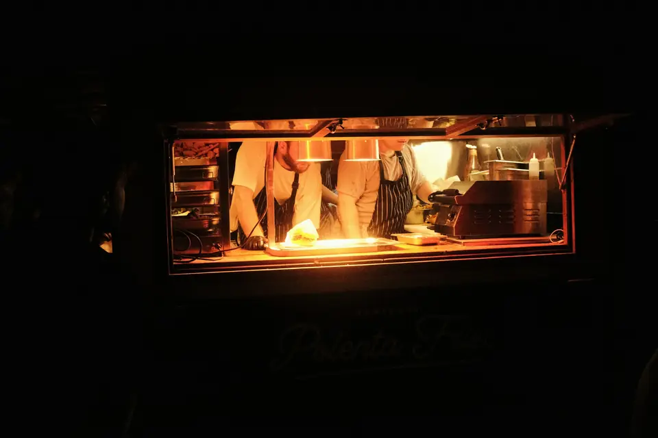 Un cuisinier au travail dans un food truck, la nuit